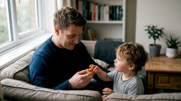Child receiving sunscreen application outdoors